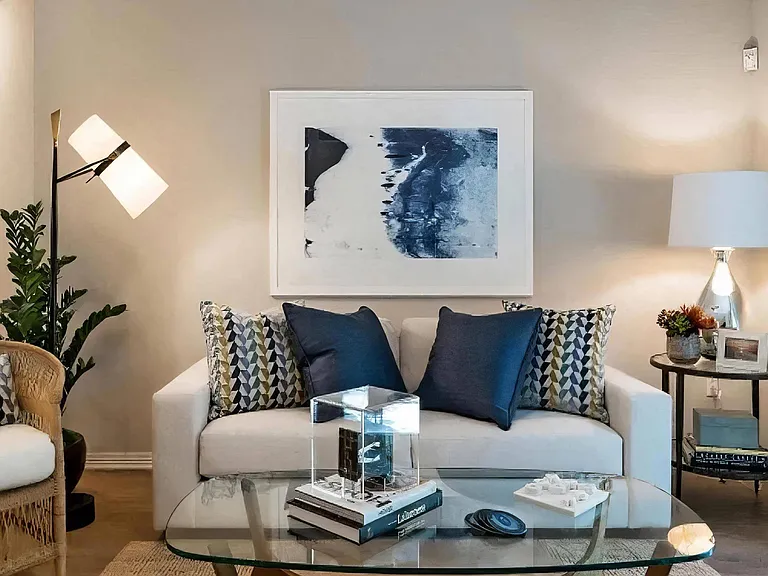 Well-Appointed Living Room with Glass Coffee Table and Soft Lighting