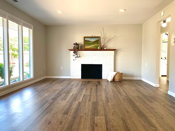 Living room into hall with large windows and luxury vinyl flooring.