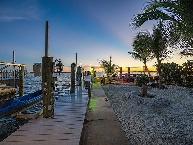 PRIVATE SANDY BEACH AREA AND WALKWAY TO DOCK GATE ENTRY AND OPEN-SEATING BAYFRONT BAR AND FIREPIT.