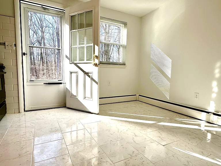 Kitchen opens to wooded backyard.