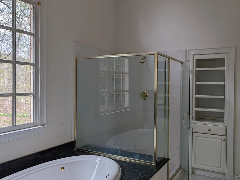 Primary Bathroom, showcasing vaulted ceiling. Walk-in closet just offscreen to the right.