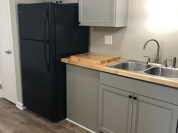 Refrigerator, cabinets, sink, and butcher block tops