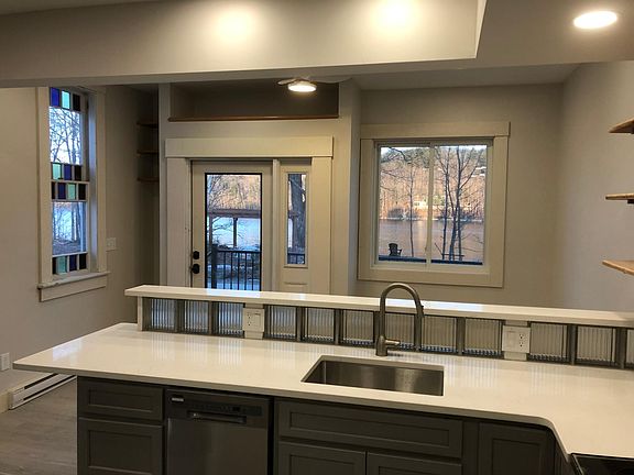 Luxury apartment kitchen with glass block backsplash, quartz countertops, and pleasing view while doing dishes!