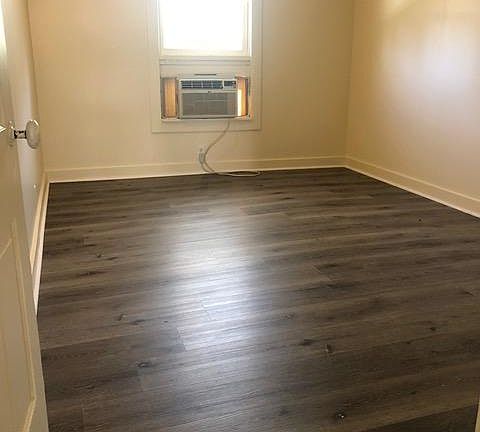 Bedroom with window air conditioner.
