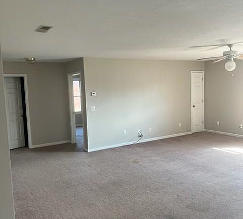 view from kitchen thru living room to bath door on left, bedroom door mid and small utility door on right