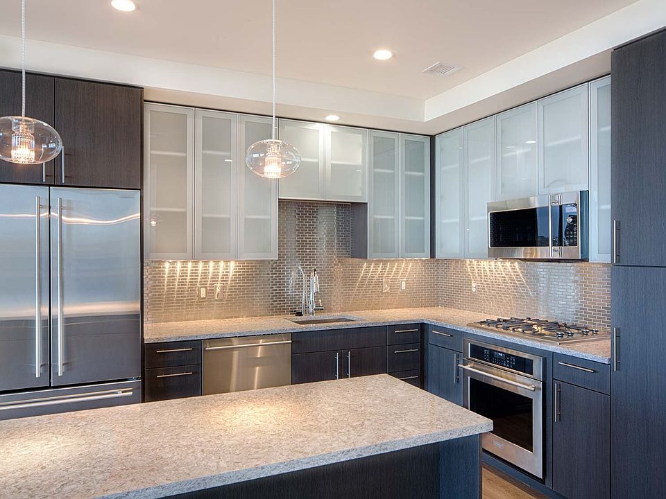 Penthouse kitchens feature frosted-glass cabinet doors, quartz countertops and breakfast bars