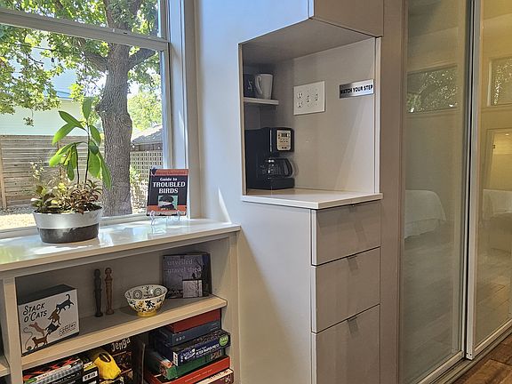 Corner coffee bar with pantry storage above and below. Side windows have view onto backyard.