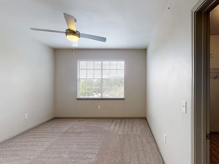 Spacious apartment bedroom with plush carpet flooring
