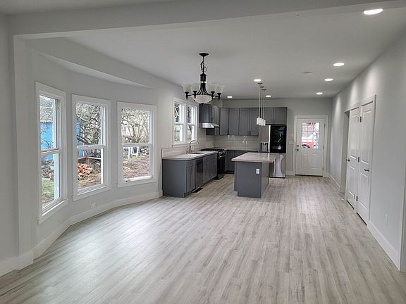 Kitchen and Living room. The new red oak hardwood floor is being installed replacing the LVP