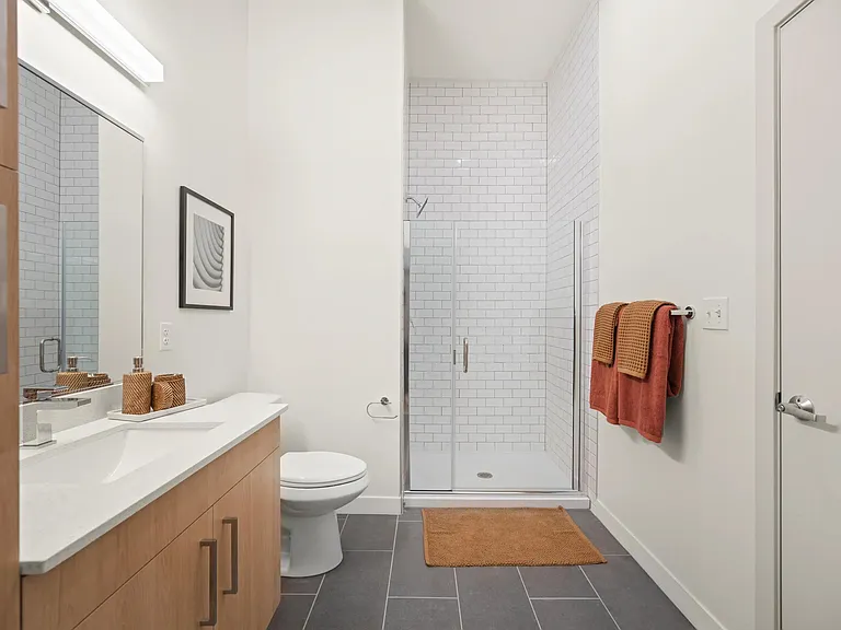 Frameless glass showers with floor-to-ceiling tile surrounds are available in select apartments.