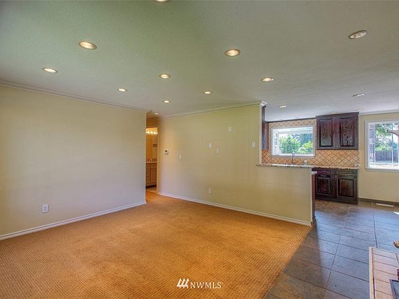 Enter into the living area with gas fireplace open to the kitchen and dining area.