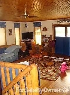Livingroom : Open floor plan with tounge and groove pine ceilings, floor, and wainscoating.