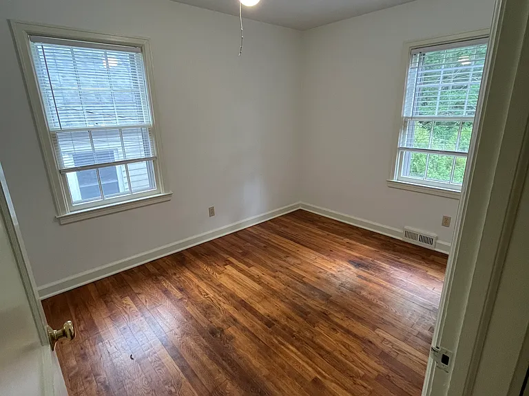 Nice large back bedroom with fan and shelves.