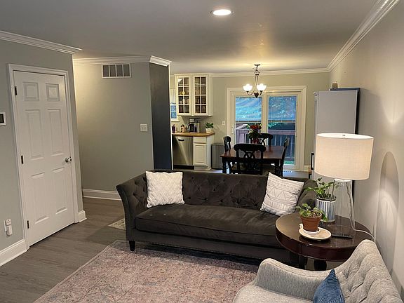 front upstairs living room looking into dining area and back slider that opens to deck