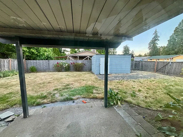 Fenced in backyard with shed