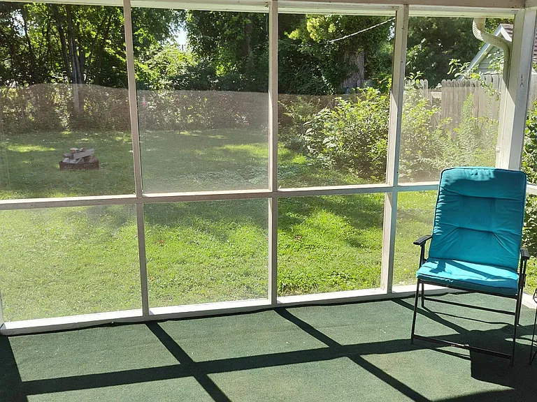 Screened back porch in fenced backyard.