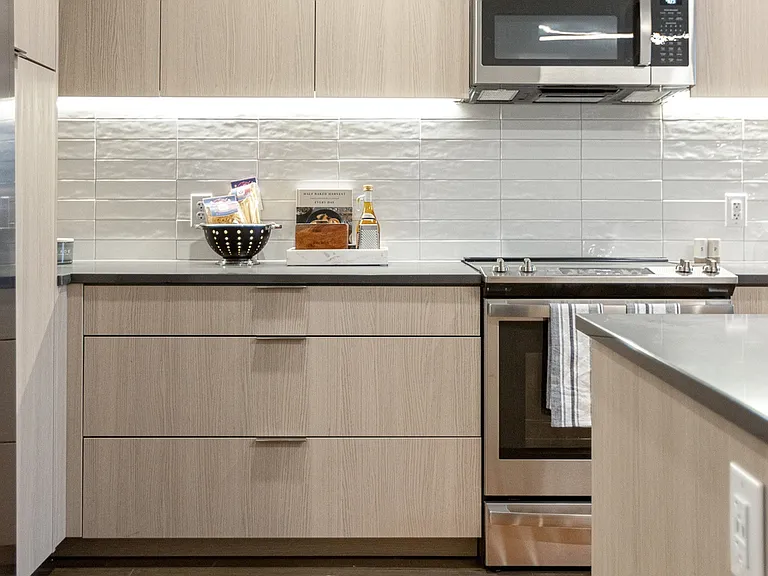 A clean and stylish kitchen featuring modern finishes, under-cabinet lighting, and a cozy pop of color.