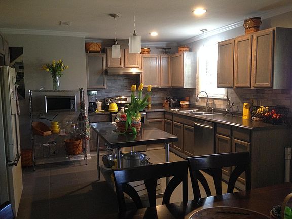 Kitchen, taken from dining area. Dishwasher and electric stove. Metal table stays as a work island.