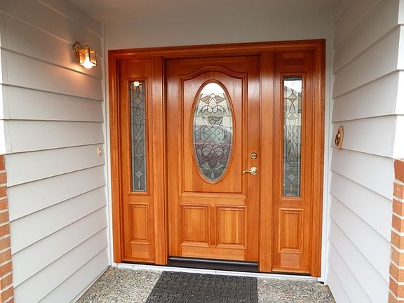 This custom built, solid, three section, Douglas-fir wood front door(a work of art), speaks to the q