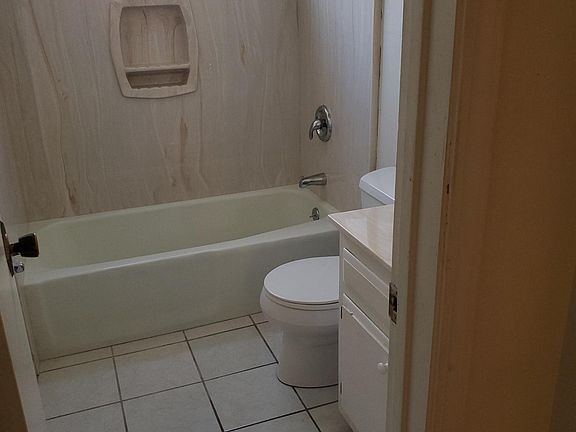 hall, complete bathroom has tub and shower, ceramic tile, vanity