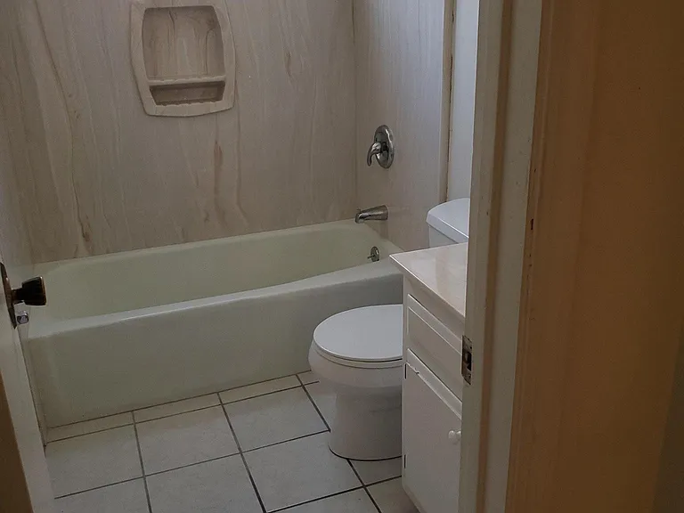 hall, complete bathroom has tub and shower, ceramic tile, vanity