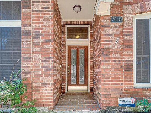 The covered front porch features decorative front door with rich hardwood surround and pretty lead glass panes.