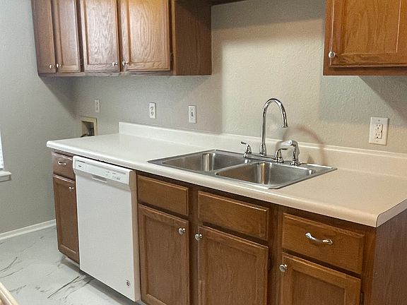 Galley kitchen with stove, refrigerator and dishwasher included view 1