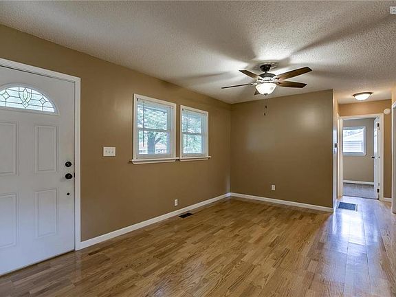 Open floor plan with wood floors and new lighting.