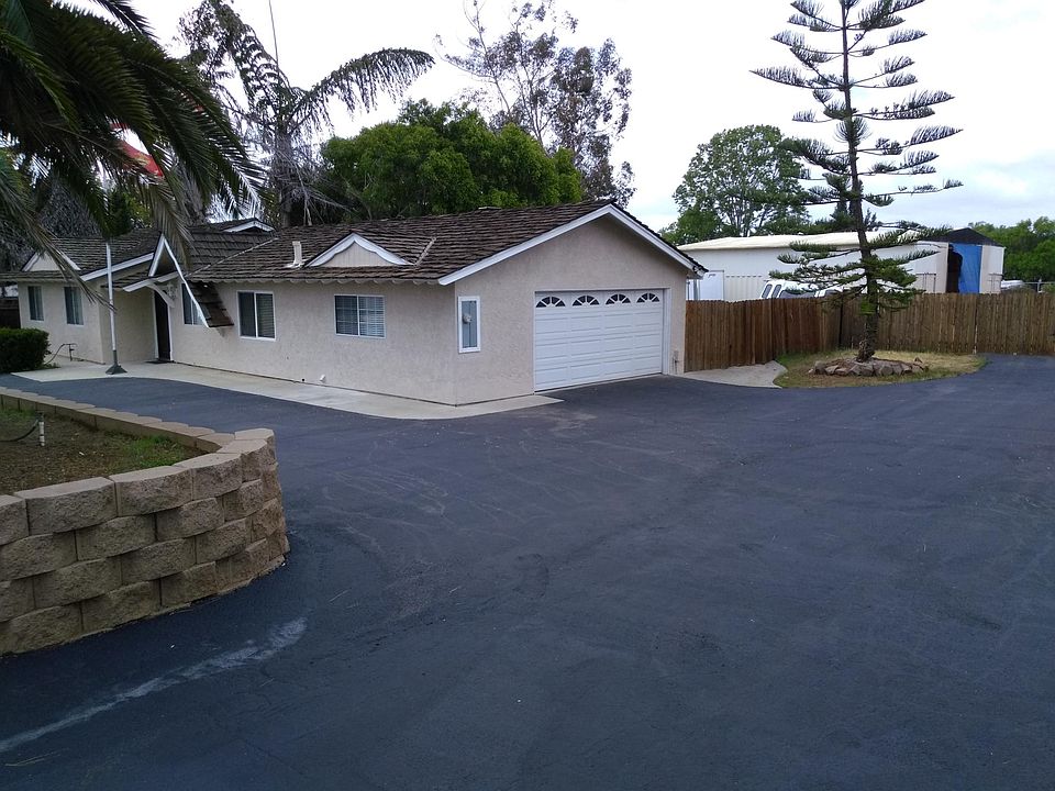 House 3/4 view. Driveway to back yard and shop in back. 