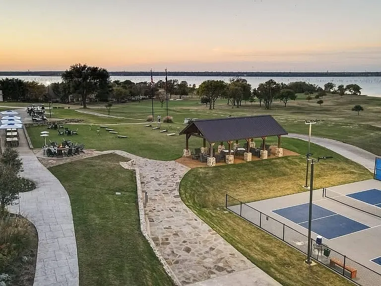 Expansive property featuring multiple pickleball courts, a covered pavilion, and a stone pathway