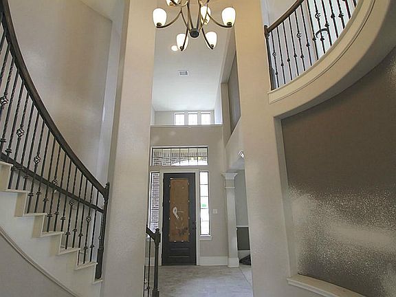BEAUTIFUL ENTRANCE WITH WROUGHT IRON SPINDLES LEADING UP UPSTAIRS.