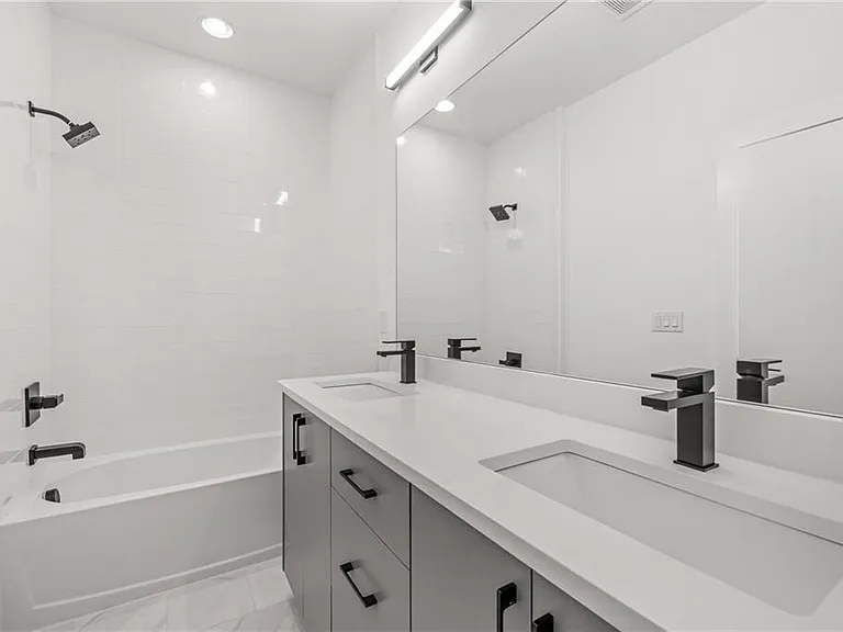 Guest Bedroom Bathroom (Note: Actual unit has light wooden floors and upgraded fixtures / appliances)