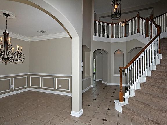 The Beveled glass front door, illuminated art niches and dramatic ceiling heights add grandeur to the Foyer.