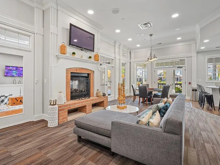 Relax and connect in an inviting community lounge featuring comfortable seating and a cozy fireplace.