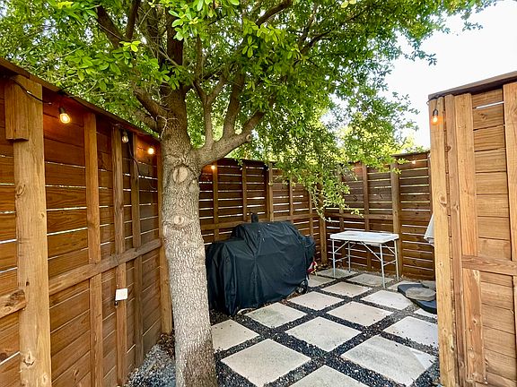 Second seating area shaded by a mature tree, perfect for relaxing outdoors