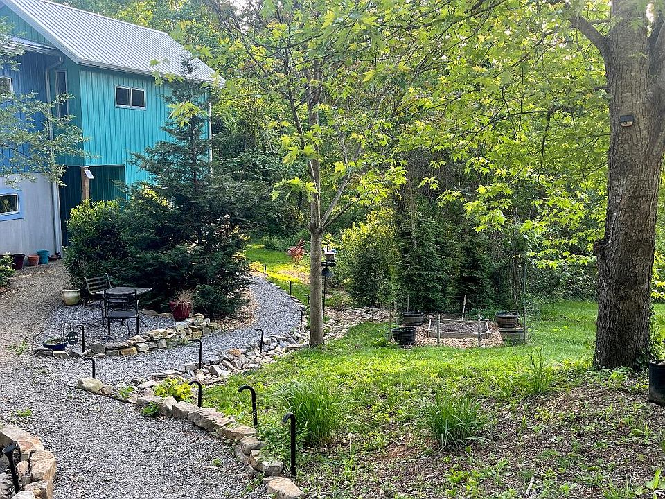 Front of house, showing path from the parking area to the apartment, plus the patio area. Raised garden bed is on the right.