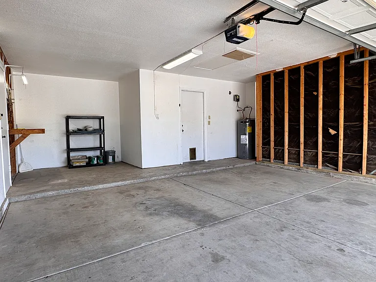 2-car garage with dedicated work space and attic-access ladder