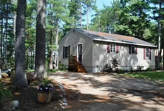 House shown fron the front entrance, lake is through the trees on the rear side of home.