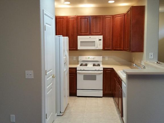 Kitchen with gas range and MW - all counters and bar top to be in granite by April 10--new double stainless undermount sink. Pantry closet to left.