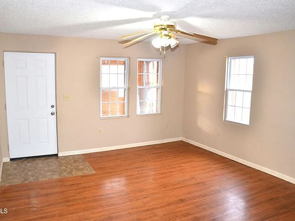 Wood laminate floors and fan in living room.