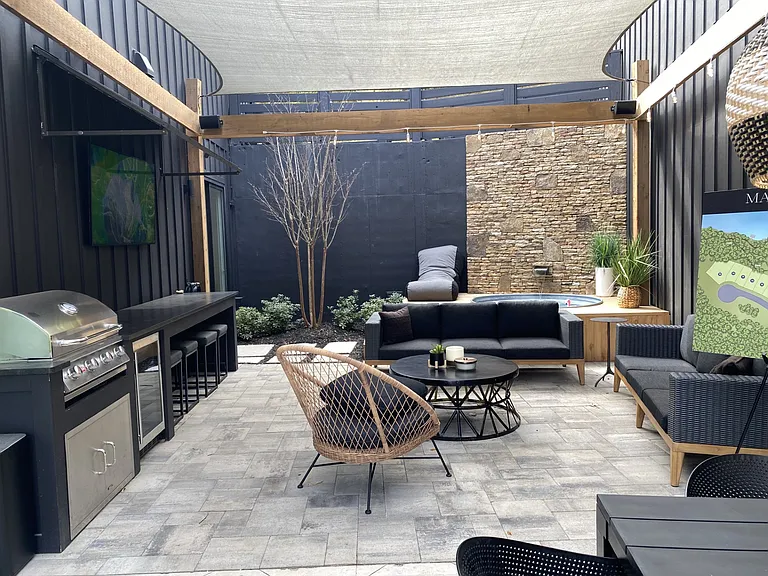 Full covered patio with grill and miniature refrigerator for relaxation and dining.