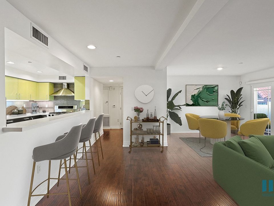 Open-Concept Kitchen with Large-Size Countertop Bar, Dining, and Living Room Space with Patio