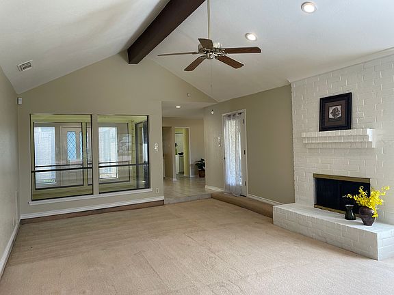 View from the expansive living room looking at the indoor light-filled atrium and a partial view of the kitchen beyond.