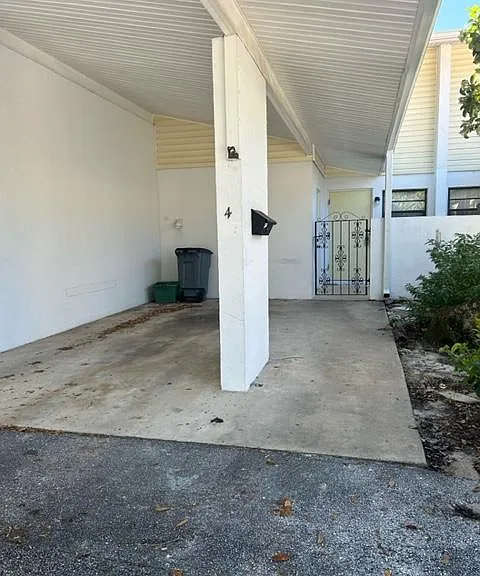Covered single car carport and home entrance.