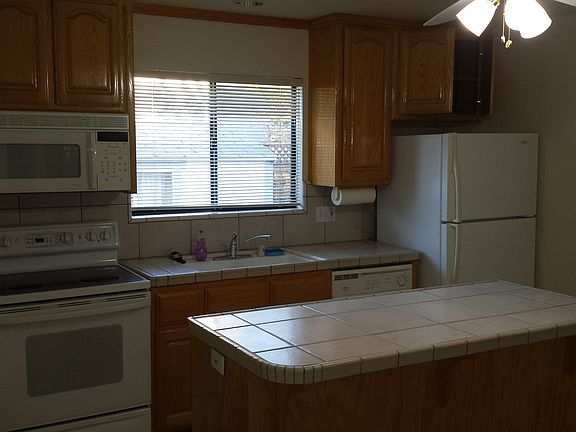 Here is the modern kitchen with Oak cabinets, tiled countertops and island.