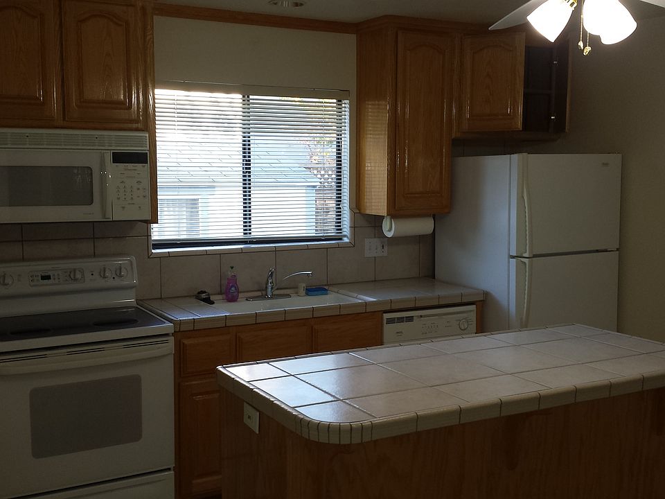 Here is the modern kitchen with Oak cabinets, tiled countertops and island.