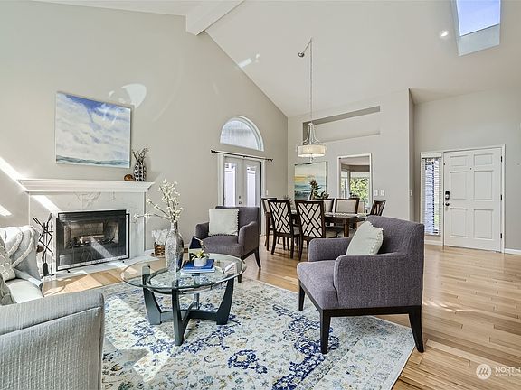 Open and airy with vaulted ceilings and a skylight in the living room and dining room. A beautiful mantled fireplace creates a warm and inviting atmosphere.>