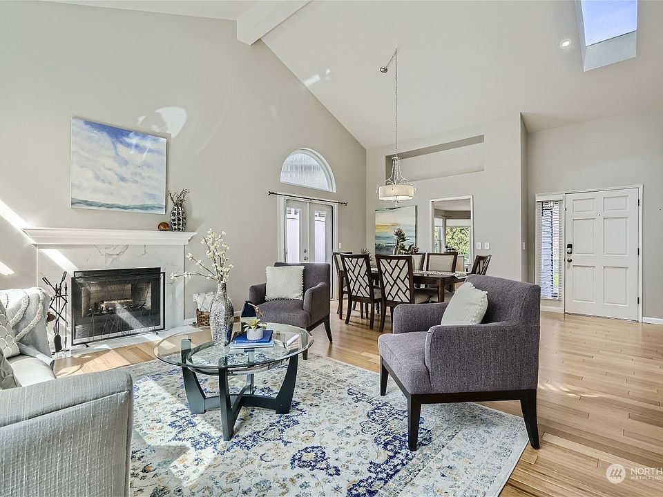 Open and airy with vaulted ceilings and a skylight in the living room and dining room. A beautiful mantled fireplace creates a warm and inviting atmosphere.>
