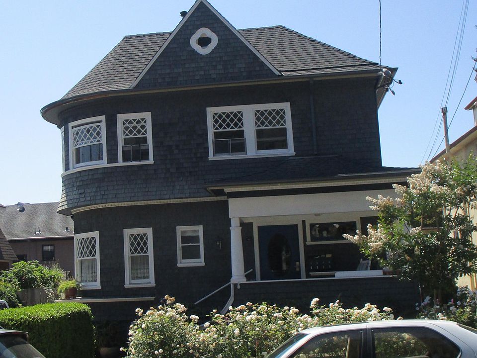 Live in a home with 1910 charm. Studio outside view from round window to end of 4-plex.