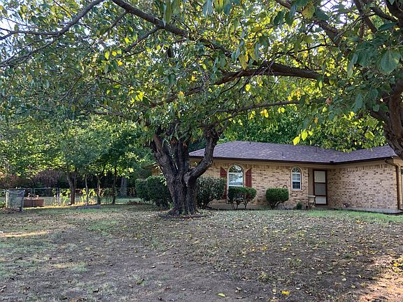 Front of house with view of left side yard and double gate.